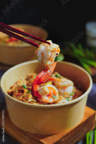 Pad Thai stir-fried with shrimp, eggs, peanuts and lime, served in paper.