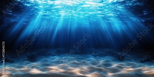Sun rays penetrating crystal-clear blue ocean water illuminating the sandy seabed with underwater rocks in the distance, creating a peaceful and serene atmosphere