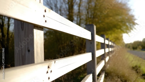 Weathered Wooden Fence Along a Rural Road with Autumnal Trees in
