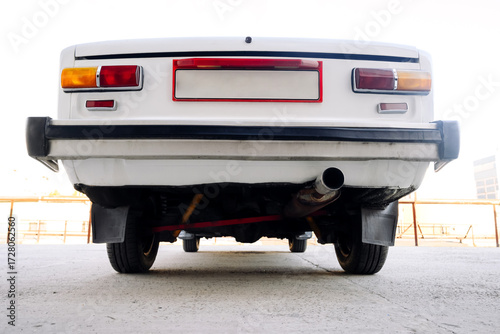 white retro car in a parking lot, rear and bottom view, close-up, retro transport concept