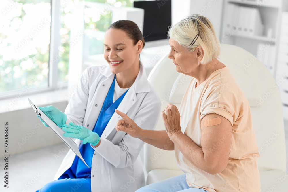 Fototapeta premium Senior woman with doctor after vaccination in clinic