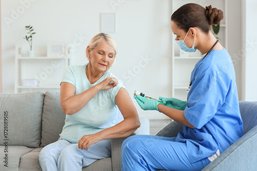 Senior woman receiving vacc...