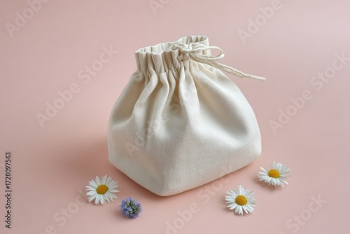 Off-white drawstring bag on pink background with flowers