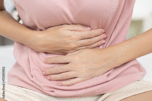 Wallpaper Mural women holding her stomach in pain, showing abdominal discomfort, menstrual cramps, bloating indigestion or digestive health issues common in women health and daily life. Torontodigital.ca