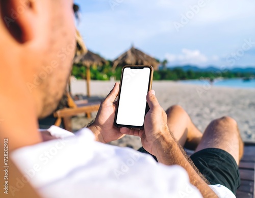Man on beach using phone