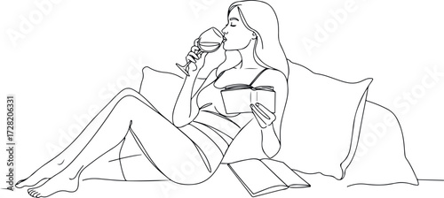 Woman enjoying wine while relaxing on a couch with a book.