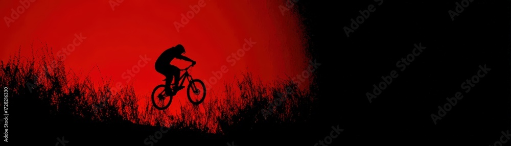 Obraz premium Silhouette of a person riding a mountain bike at sunset with a red sky and natural landscape background, outdoor cycling adventure scene