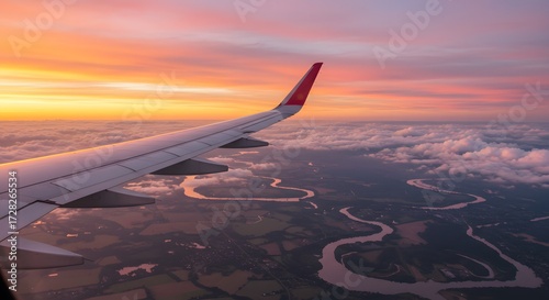 Airplane wing over landscape sunrise