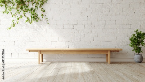 A simple, light-filled room features a light-colored wooden bench against a white brick wall with a small plant.