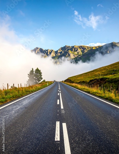 Winding asphalt road through misty mountain valley