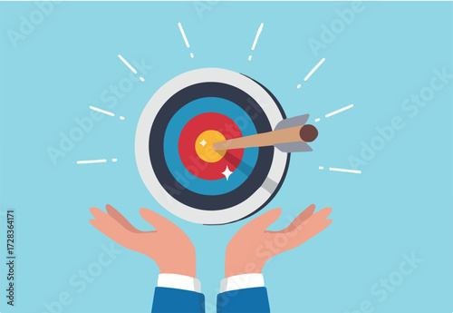 Goal or target, focus and concentration to achieve success, purpose or objective, aiming at target bullseye, accuracy, challenge and aspiration, businessman hand hold target with arrow hit bullseye.