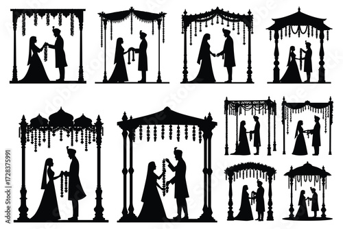 Indian wedding couple exchanging garlands under ornate mandap silhouettes
