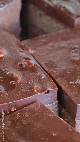 Freshly baked slices of chocolate brownies on display on a market stall.