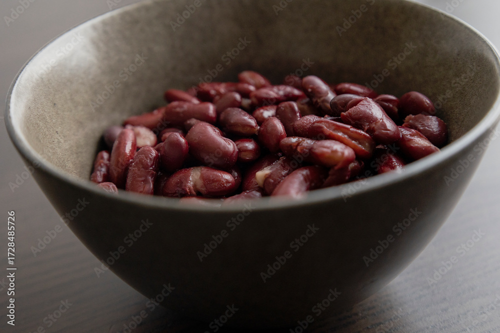 Obraz premium Red Beans in Dark Bowl on Moody Black Background Close-Up