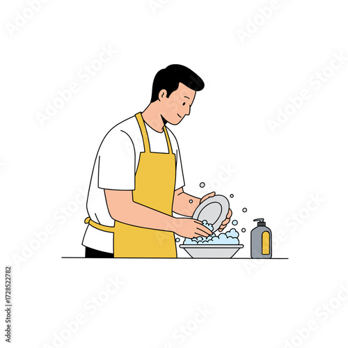 Man washing dishes in yellow apron by sink with soap bubbles  