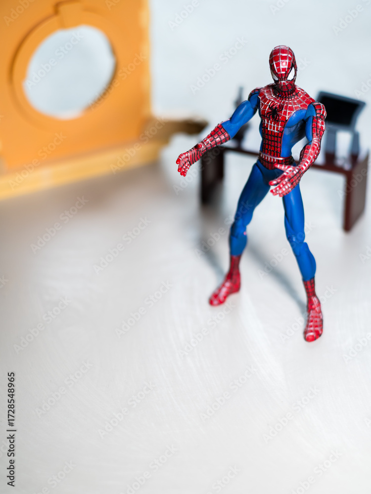 Naklejka premium Spider Man figure in his office with desktop and Computer.
