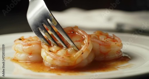 Shrimp dish being forked, elegant dining setting
