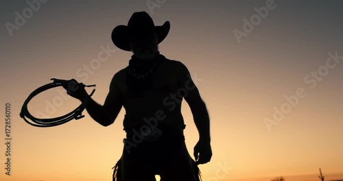 Silhouette of a Cowboy at Sunset with Roping Gear