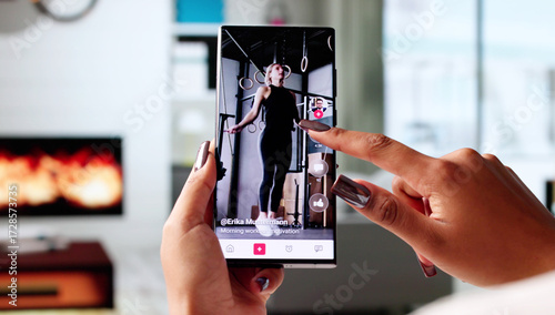 Young African American Woman Scrolling Through Videos On Mobile Phone