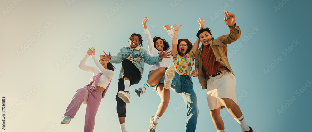 Fototapeta premium Group of friends laughing and jumping outdoors