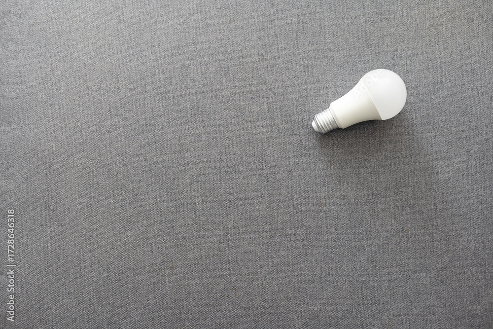 Naklejka premium Electric light bulb on a gray background