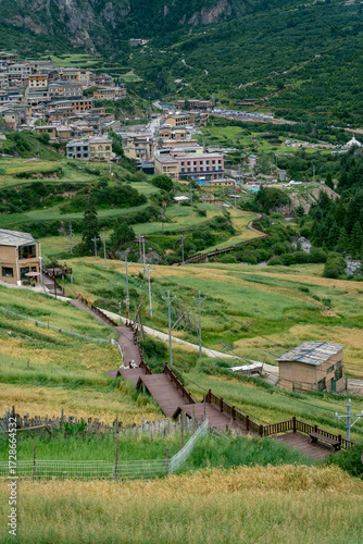 Wooden plank road in the town among the green mountains