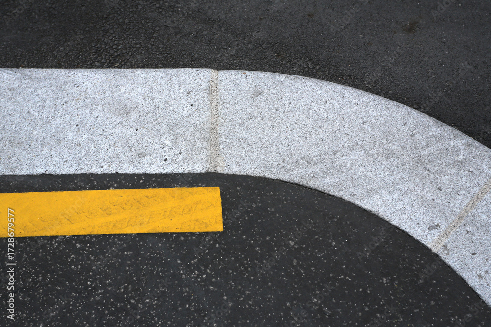 Fototapeta premium Bordure de trottoir sur une route avec ligne jaune