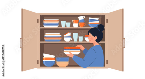 A woman with a bun hairstyle organizing colorful dishes, plates, bowls, and cups in an open kitchen cabinet with multiple shelves.