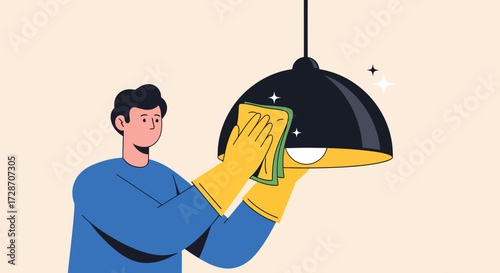 A person wearing yellow gloves cleans a black pendant light fixture with a green cloth.