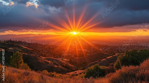 Sunset Over Hills with City Vista and Sun Rays Peeking Through