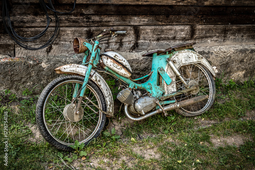 The old and rusty abandoned motorcycle moped