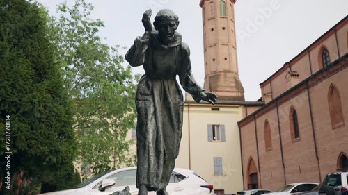 Bronze statue of Saint Francis of Assisi being an Italian mystic, poet and catholic friar who founded the religious order of the Franciscans, historical art monument with small fountain on the