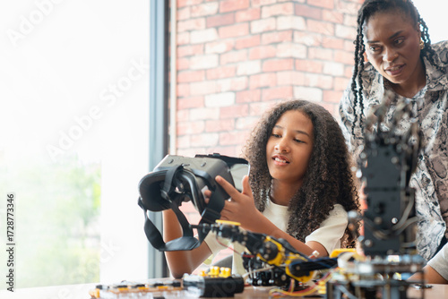 Teacher and Student Exploring Virtual Reality in a STEM Class, Young Girl Holding VR Headset While Learning Robotics and Technology, Future of Learning Immersive Technology in Education