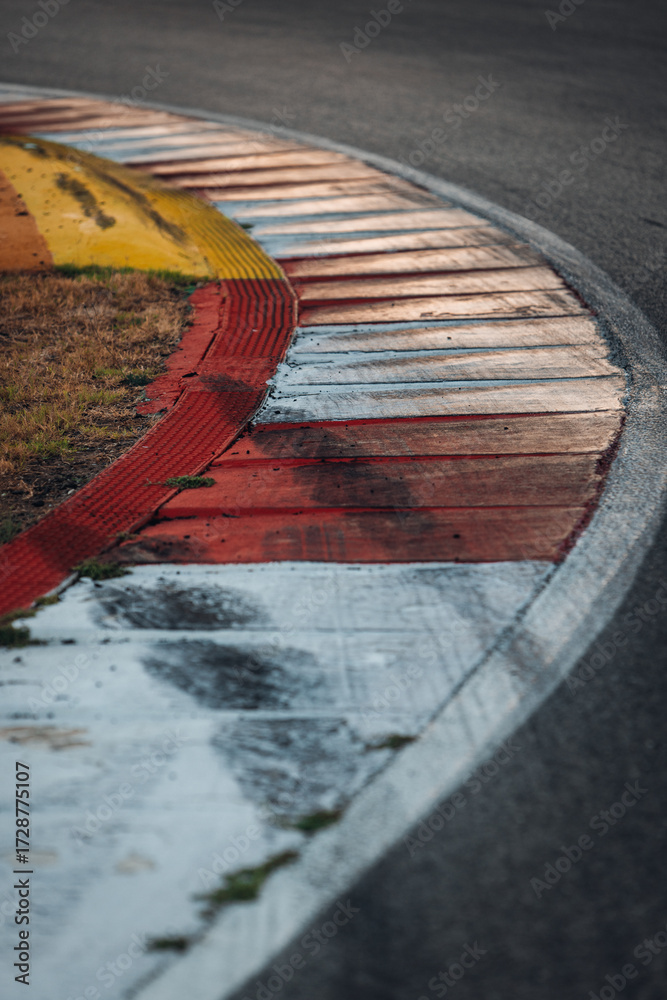 Fototapeta premium Race Track Curb with Tire Marks – Red, White and Green Kerbs Close-Up