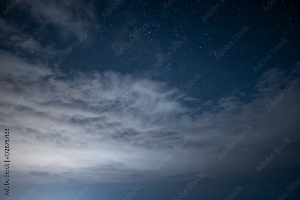 Obraz premium Night sky with scattered clouds and visible stars