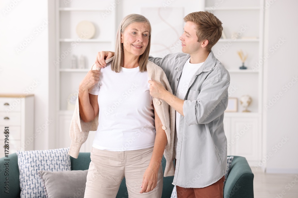 Obraz premium Son taking care of his happy mother at home. Family bonding