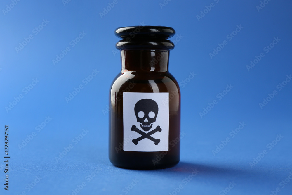 Obraz premium Bottle of poison with warning sign on light blue background, closeup