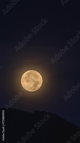 Full moon setting over dark mountains in Kotor, Montenegro, on September 7, 2025, glowing in deep night sky with soft halo and serene landscape. Time lapse