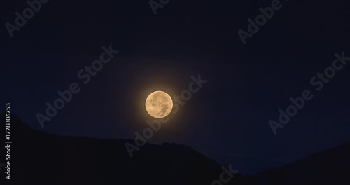 Full moon setting over dark mountains in Kotor, Montenegro, on September 7, 2025, glowing in deep night sky with soft halo and serene landscape. Time lapse