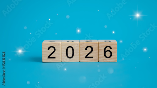 Professional photo of 2026 Happy New Year wooden cube blocks transitioning from 2025, on vibrant blue background with minimal modern holiday celebration design.