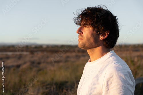 Fotografi Man finding peace during golden hour, reflecting in nature, enjoying the serene