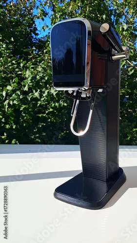 Soda making machine at home.A woman takes a bottle out of the device.