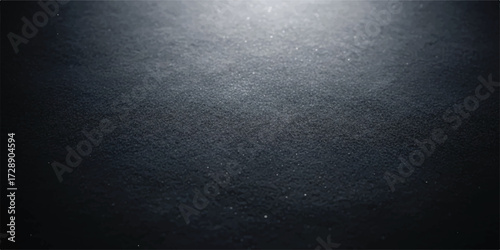 Single small spotlight on black textured background offering a sense of drama and focus