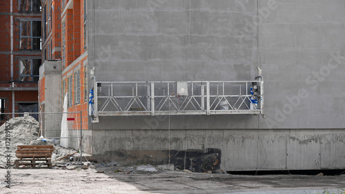 Fotografía suspended facade cradle for facade installation in a new building