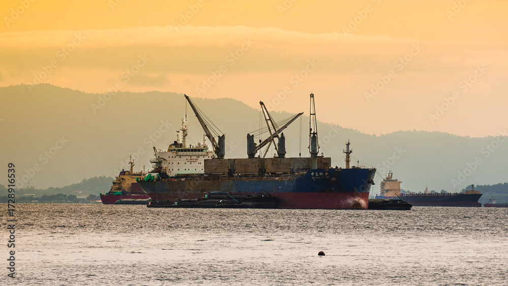 Fototapeta premium Cargo ship at sea during sunset.