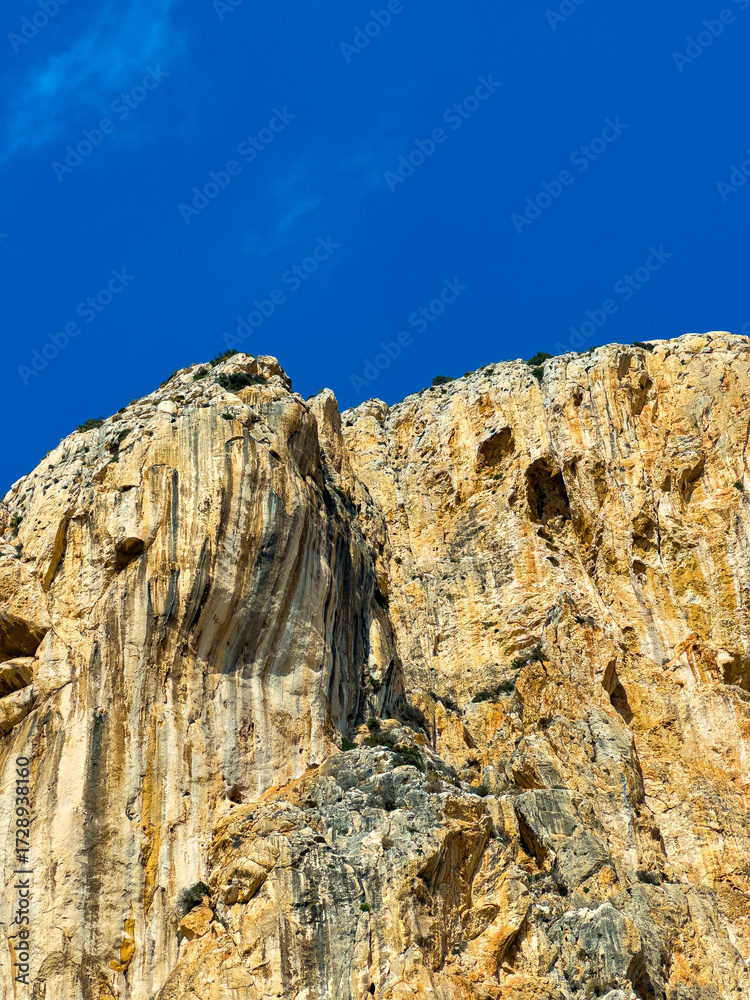 Fototapeta premium Stunning rock formation under a clear blue sky in a mountainous landscape during a sunny day