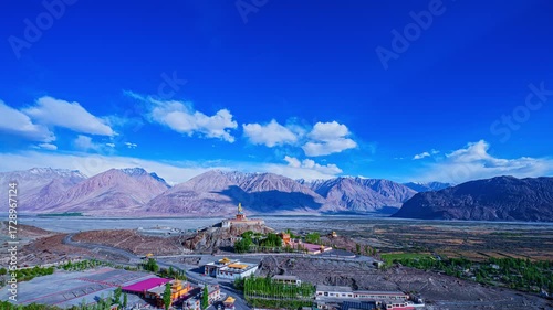 The sacred Diskit Monastery statue stands tall on a mountaintop in the vast valley Himalayas. Diskit Gompa is the oldest and largest Buddhist monastery in the Nubra Valley of Ladakh, northern India.