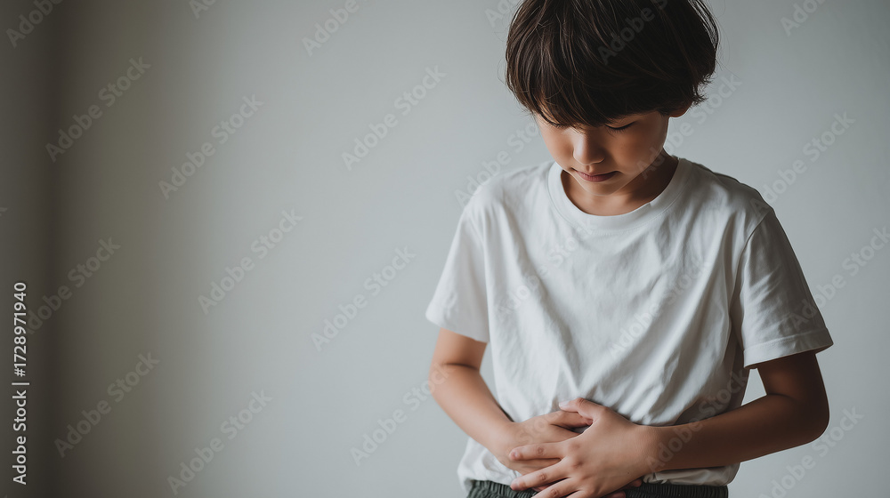 Obraz premium Japanese Child 6 years old holding stomach in discomfort