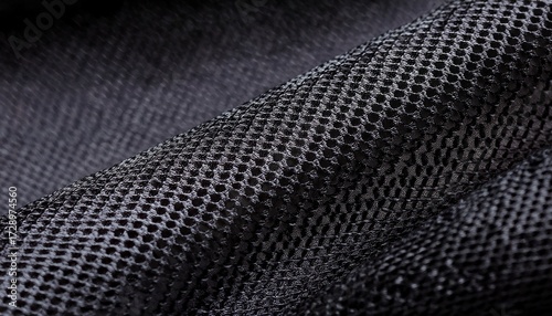 a close up of a black mesh fabric with a circular knit pattern highlighting the texture weave structure and breathability ideal for textile and design references
