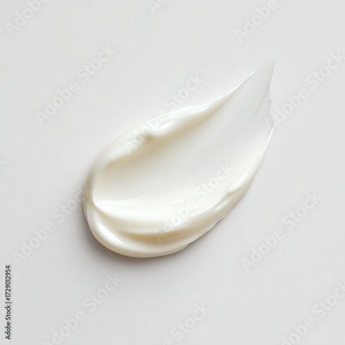 Creamy white skincare product smear on a clean, neutral background